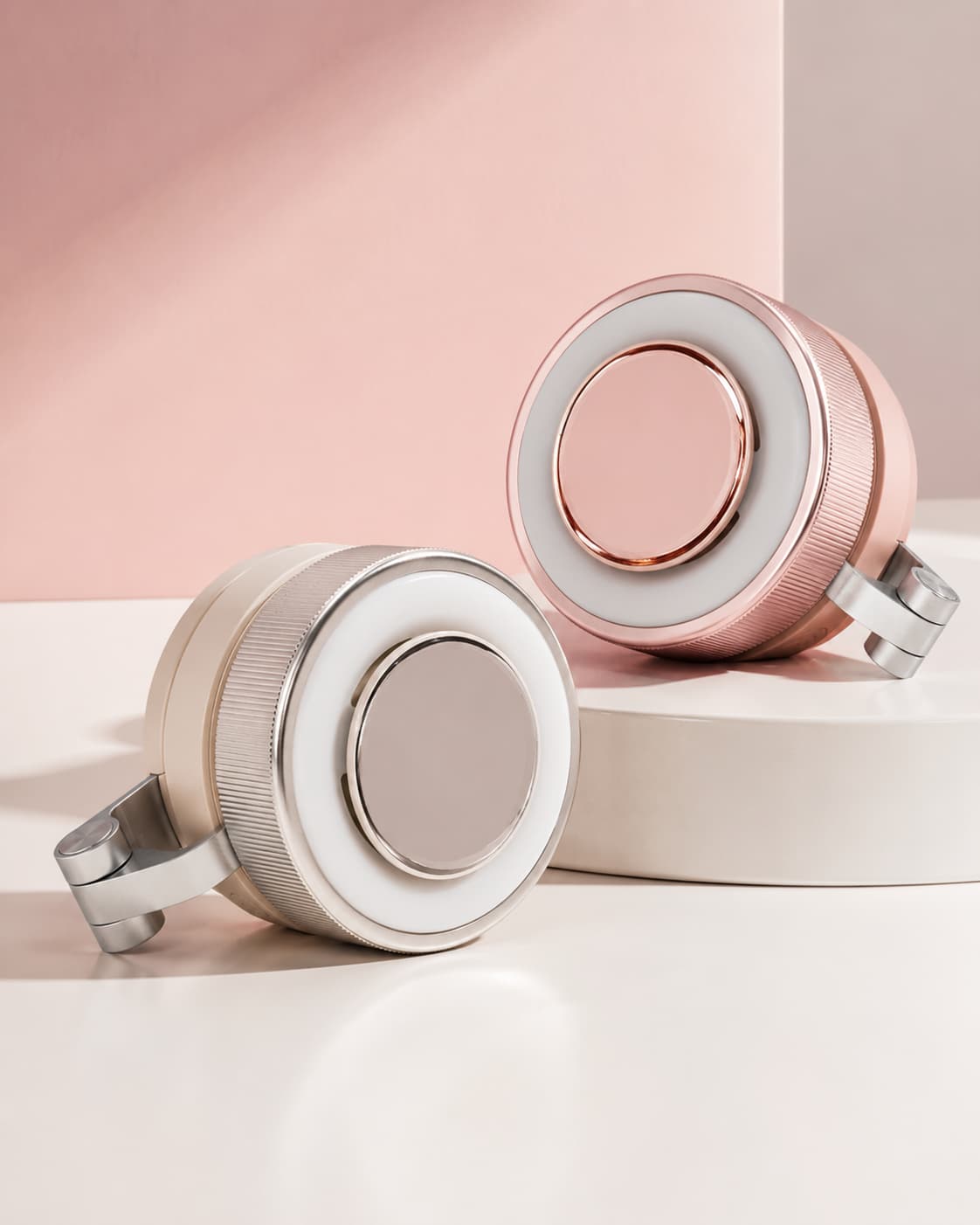 Close-up of the MagCool portable bladeless fan variants in minimalist white and pink sitting on a smooth surface