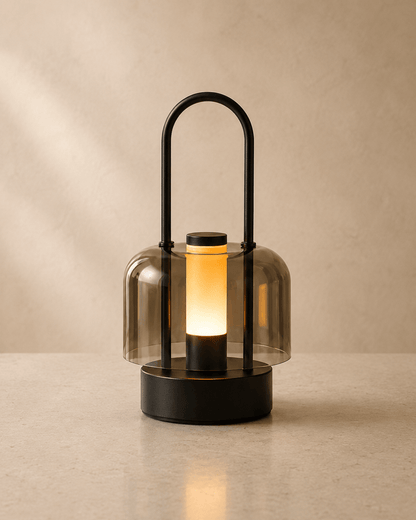 Black portable LED ambient lamp with warm glow and smoked acrylic shade placed on tabletop for indoor home decor
